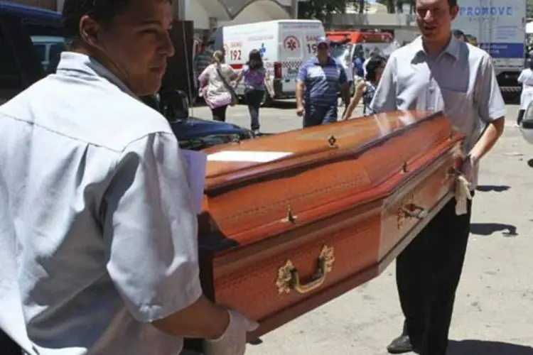 Homens carregam caixão com corpo de uma das vítimas: 232 pessoas morreram (Reuters)
