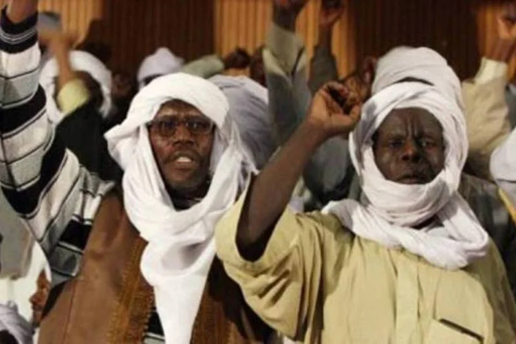 Homens erguem os punhos durante manifestação pró-governo em Kufra, Líbia (Mahmud Turkia/AFP)