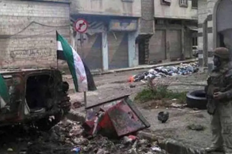 Foto divulgada pela oposição mostra rebelde ao lado de tanque do regime destruído em Homs (AFP)