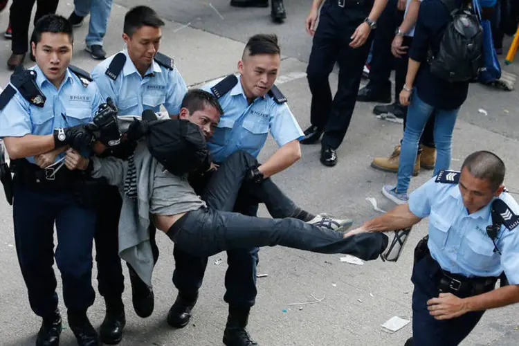 Policiais tentam deter manifestante pró-democracia em Hong Kong (REUTERS/Bobby Yip)