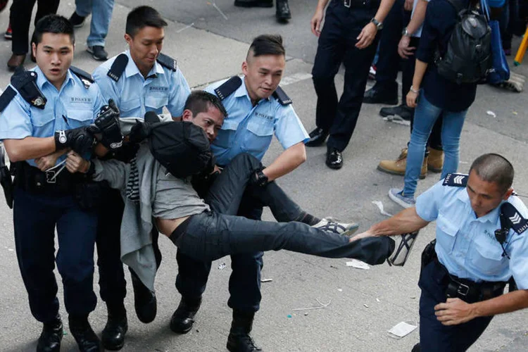Policiais tentam deter manifestante pró-democracia em Hong Kong (REUTERS/Bobby Yip)