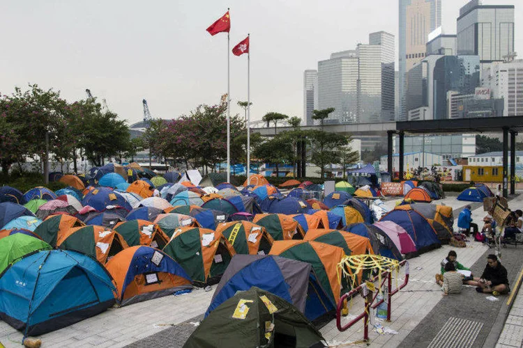 
	Bandeiras da China e de Hong Kong vistas acima de barracas de manifestantes acampados em &aacute;rea ocupada de Hong Kong
 (Tyrone Siu/Reuters)