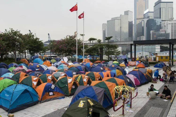 Bandeiras da China e de Hong Kong vistas acima de barracas de manifestantes acampados em área ocupada de Hong Kong (Tyrone Siu/Reuters)