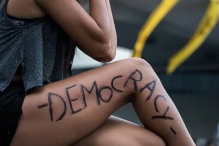 
	Manifestante de Hong Kong exibe a palavra democracia escrita em sua perna
 (Alex Ogle/AFP)
