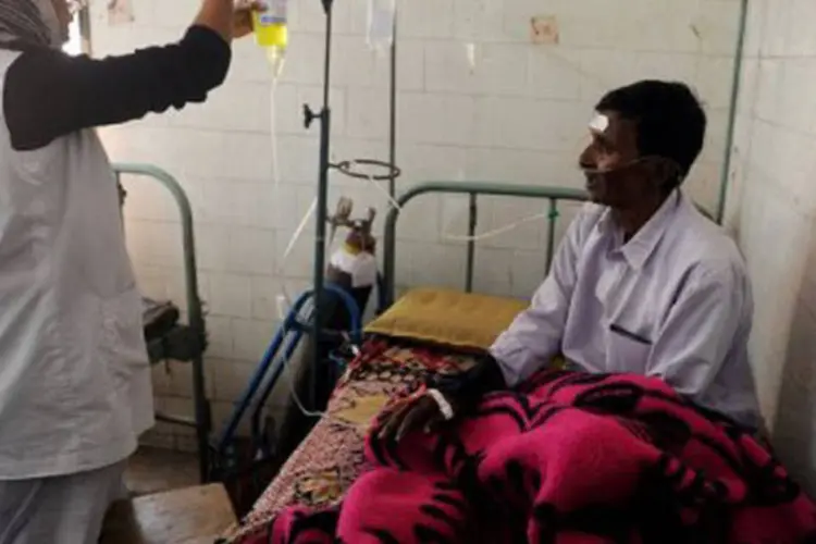 Homem recebe tratamento após ingerir álcool adulterado na Índia, em 17 de dezembro, mês em que 170 pessoas morreram envenenadas
 (Dibyangshu Sarkar/AFP)