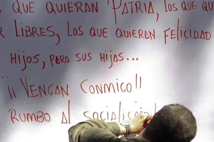 Hugo Chávez escreve uma mensagem na parede, em uma foto de dezembro de 2008 (Jorge Silva/Reuters)
