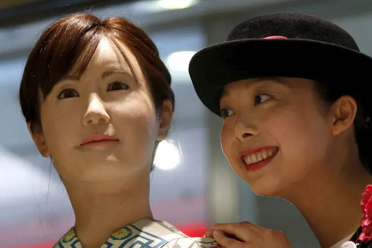 
	Uma atendente da loja de departamento japonesa posa ao lado do rob&ocirc; humanoide: falando em japon&ecirc;s, Aiko, que tem fei&ccedil;&otilde;es humanas e pisca os olhos
 (REUTERS/Issei Kato)