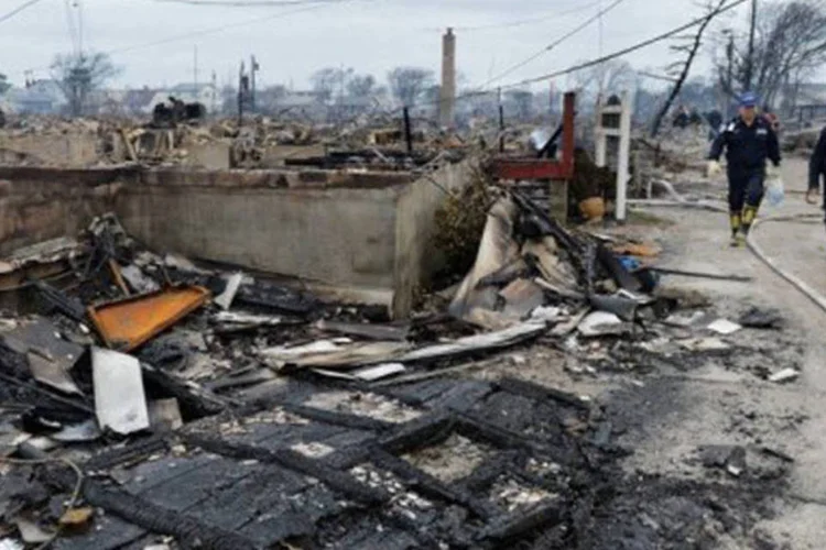 Moradores observam uma área danificada no Queens, NY: se forem somadas as 67 vítimas fatais de Sandy no Caribe e os dois mortos no Canadá, o saldo chega a 154 mortos (©AFP / Stan Honda)