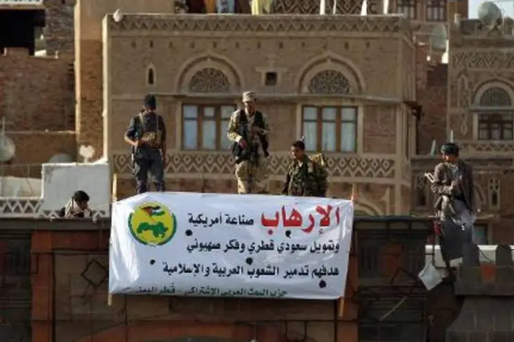 Rebeldes xiitas huthis montam guarda em Sana: dezenas de milícias huthis e seus aliados, que chegaram a bordo de blindados de transporte de tropas, entraram no palácio presidencial Al-Maashiq (Mohammed Huwais/AFP)