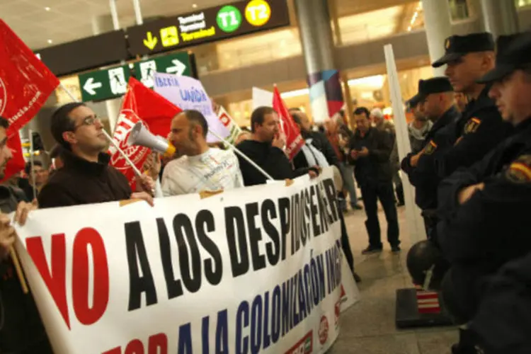 Funcionários da Iberia em greve protestam no aeroporto de Málaga, na Espanha. O banner diz: "Não às demissões na Península Ibérica. Pare a colonização britânica" (REUTERS / Jon Nazca)