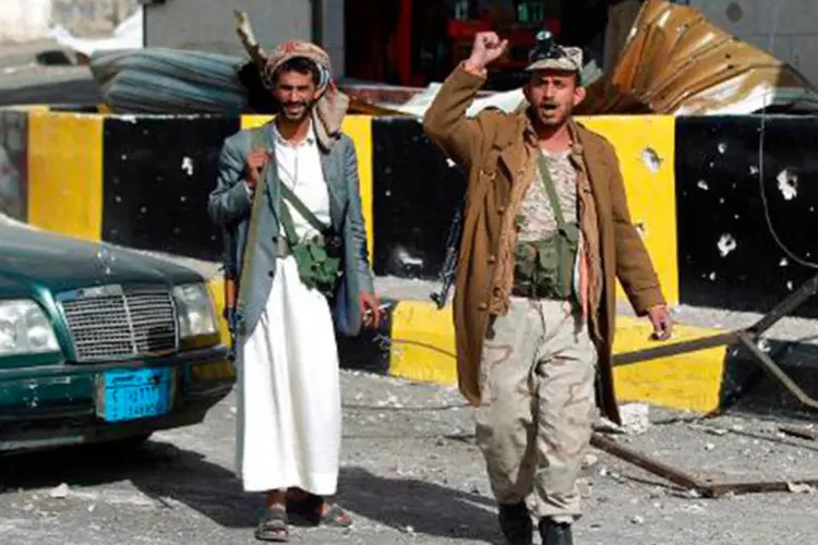Rebeldes xiitas fazem gestos de luta do lado de fora do palácio presidencial do Iêmen  (Mohammed Huwais/AFP)