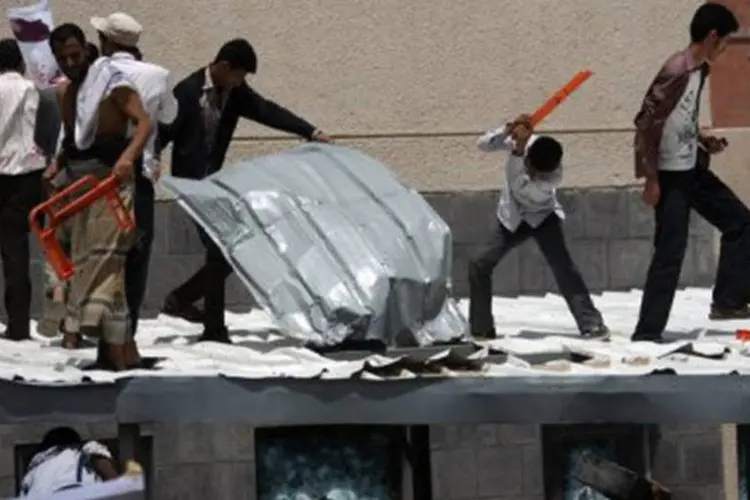 
	Iemenitas quebram telhado e vidros da embaixada americana
 (Mohammed Huwais/AFP)