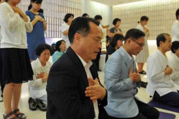 
	Fi&eacute;is da Igreja da Unifica&ccedil;&atilde;o realizam uma cerim&ocirc;nia em mem&oacute;ria ao l&iacute;der da seita em Seul: dezenas de fieis manifestaram afli&ccedil;&atilde;o no portal da igreja
 (Kim Jae-Hwan/AFP)