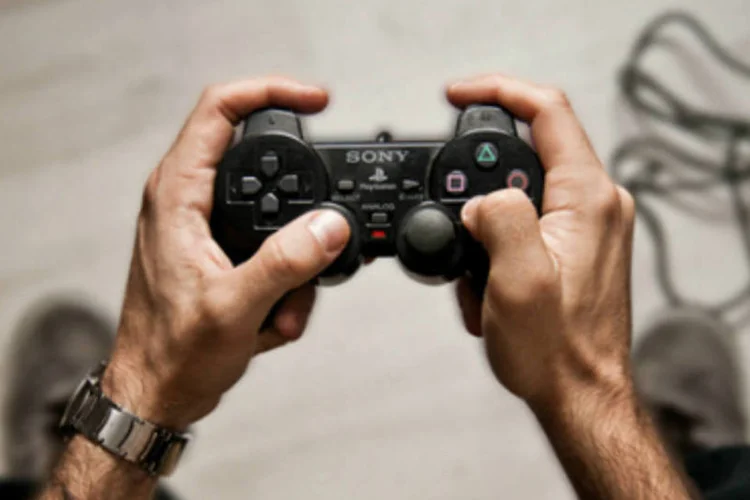 Homem segura o controle do console Playstation 2, da Sony (Reprodução/Javier Laspiur)
