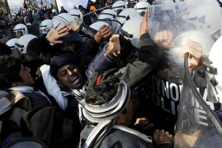 Confronto entre polícia e imigrantes na fronteira entre Grécia e Macedônia: policiais macedônios usaram gás lacrimogêneo para repelir a multidão (Alexandros Avramidis/Reuters)