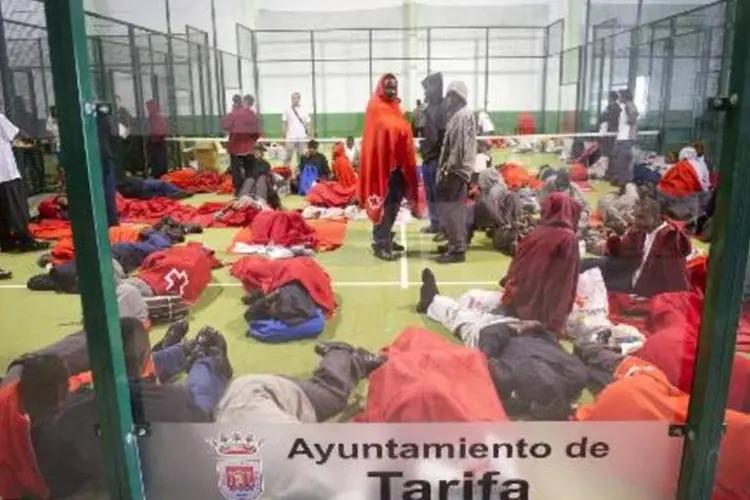 Imigrantes descansam após serem resgatados pela guarda costeira da Espanha (Marcos Moreno/AFP)