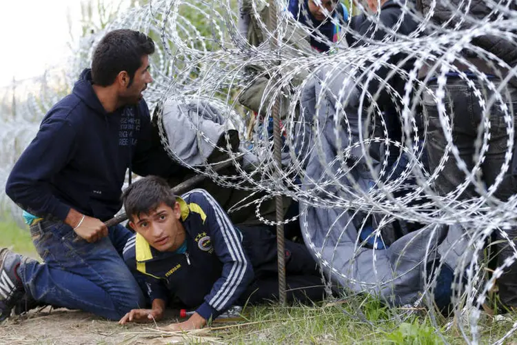 
	Refugiados cruzam arame farpado na Hungria: texto fala que situa&ccedil;&atilde;o &eacute; consequ&ecirc;ncia de declara&ccedil;&otilde;es de &quot;irrespons&aacute;veis pol&iacute;ticos europeus&quot; que encorajam refugiados a &quot;se dirigir para a Europa&quot;
 (Reuters / Laszlo Balogh)