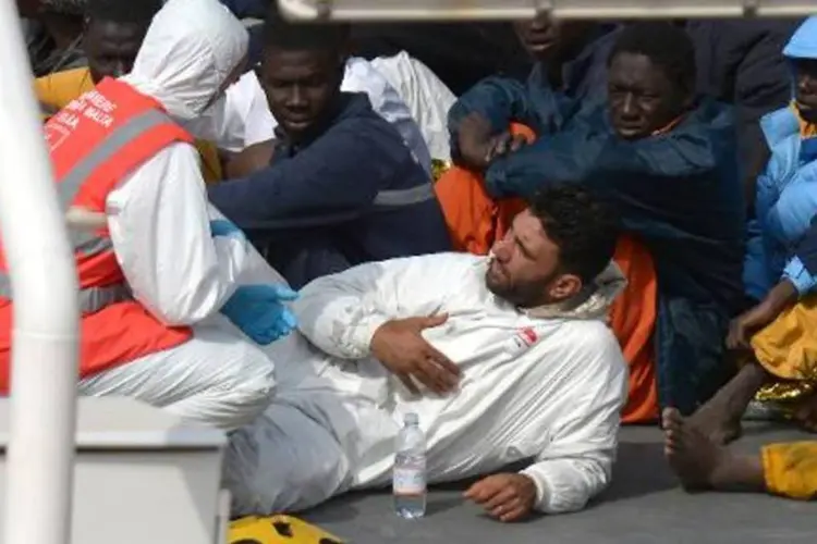 Imigrantes conversam com integrante de equipe de resgate em Malta (Matthew Mirabelli/AFP)