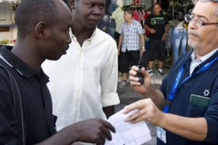 Funcionário da imigração analisa documentos de africanos na cidade de Tel Aviv: Israel pretende expulsar 1.500 sul-sudaneses em situação irregular (Jack Guez/AFP)