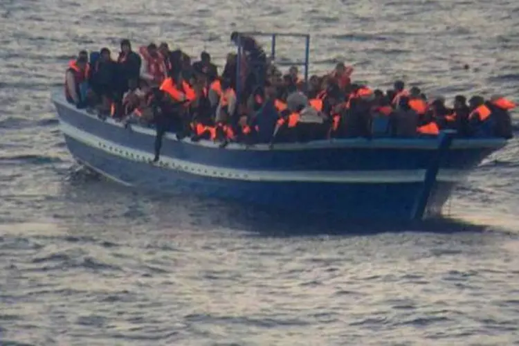 
	Embarca&ccedil;&atilde;o com imigrantes perto da ilha de Lampedusa
 (Ho/AFP)