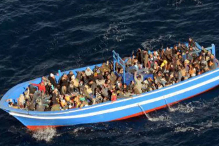 
	Imigrantes em bote na It&aacute;lia: o pa&iacute;s j&aacute; recebeu, desde janeiro, 69.415 imigrantes
 (AFP)