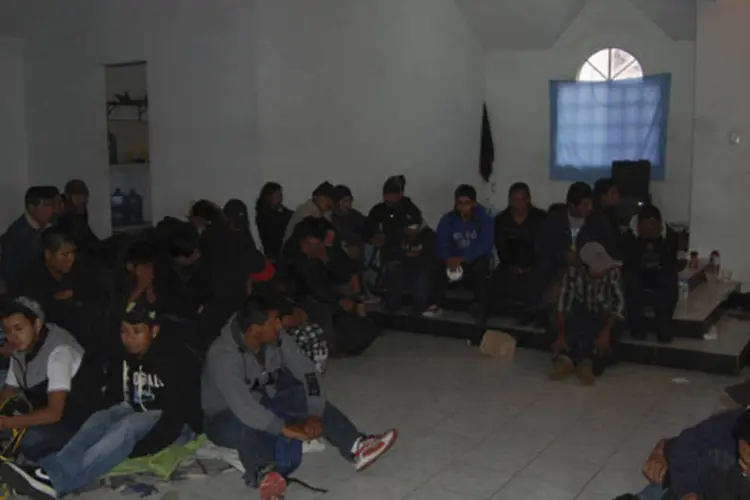 Imigrantes sentados em um casa onde foram resgatados por soldados do Exército, perto da fronteira mexicana com os Estados Unidos (Secretaria de Gobernacion/Divulgação via Reuters)