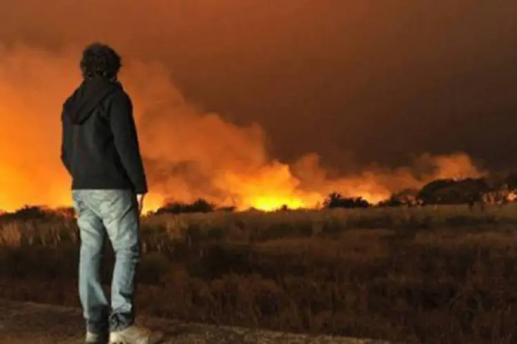 Um homem observa o incêndio na Reserva Ecológica de Buenos Aires: a Reserva já sofreu vários incêndios e na maioria dos casos foram intencionais. (AFP / Carlos Brigo)