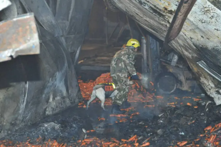 Membro de equipe de segurança faz buscas por vítimas de incêndio e fábrica alimentícia na China (Xinhua/Reuters)