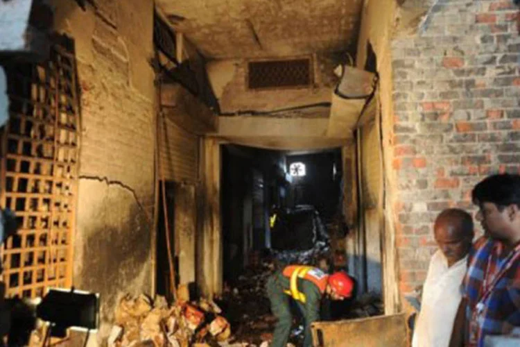 Equipe de resgate investiga em 12 de setembro de 2012 a fábrica de sapatos destruída por um incêndio Lahore, no Paquistão
 (Arif Ali/AFP)