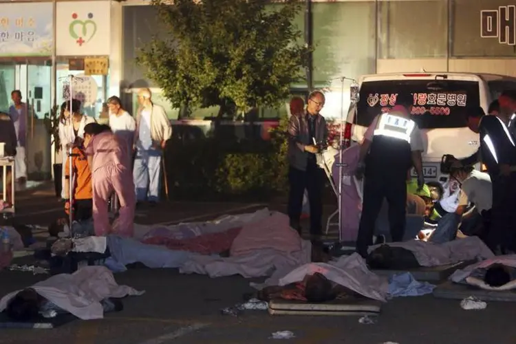 Pacientes resgatados de um hospital em chamas deitam em frente ao prédio, em Jangseong, a cerca de 300 quilômetros de Seul, Coreia do Sul (Hyung Min-woo/Yonhap/Reuters)