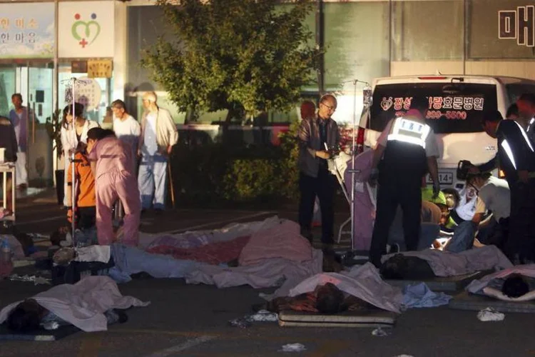 Pacientes resgatados de um hospital em chamas deitam em frente ao prédio, em Jangseong, a cerca de 300 quilômetros de Seul, Coreia do Sul (Hyung Min-woo/Yonhap/Reuters)