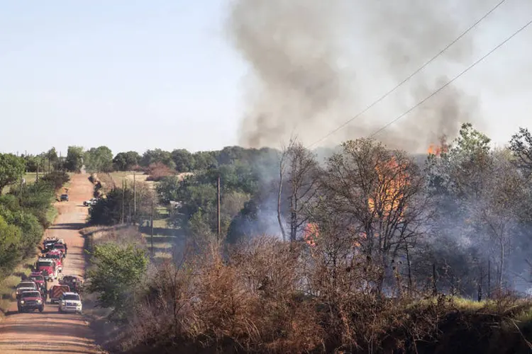 Bombeiros combatem incêndio no Condado Logan, perto de Guthrie, em Oklahoma, nos Estados Unidos, nesta segunda-feira (Richard Rowe/Reuters)