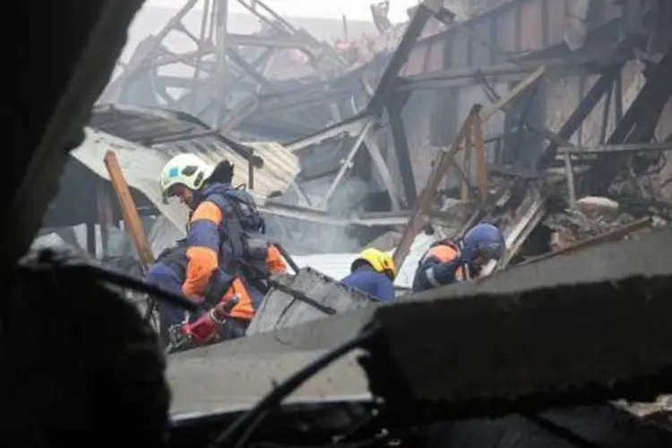 Bombeiros trabalham em centro comercial destruído por incêndio na cidade de Kazan (HO/AFP)