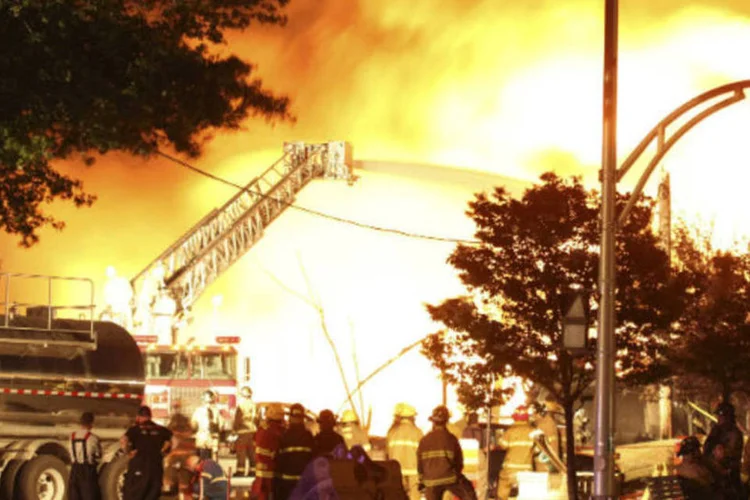 Bombeiros tentam apagar um incêndio provocado pela explosão de um trem que transportava petróleo em Quebec, no Canadá
 (Transportation Safety Board of Canada/Divulgação via Reuters)
