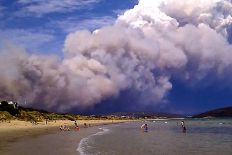 Fumaça de incêndio florestal fica sobre a praia em Carlton, 20 km a leste de Hobart, na Austrália (Joanne Giuliani/Reuters)