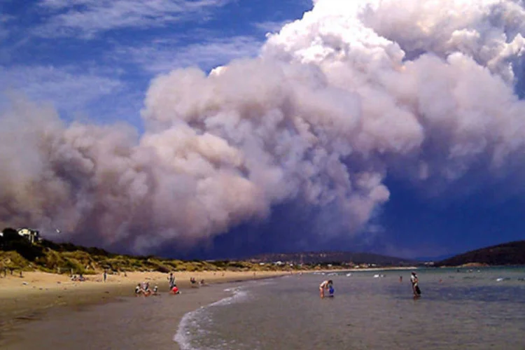 Fumaça de incêndio florestal fica sobre a praia em Carlton, 20 km a leste de Hobart, na Austrália (Joanne Giuliani/Reuters)