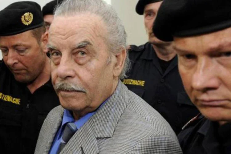 
	Joseph Fritzl &eacute; escoltado por policiais: ele foi condenado &agrave; pris&atilde;o perp&eacute;tua pela morte de um beb&ecirc; nascido no por&atilde;o onde mantinha sua filha, com quem teve sete filhos
 (Robert Jaeger/AFP)