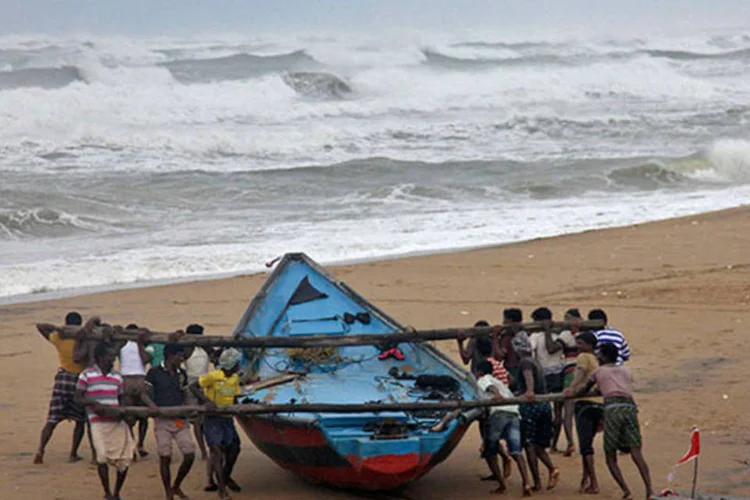 Pescadores levam barco a lugar mais seguro devido à aproximação do ciclone Hudhud (REUTERS/Stringer)