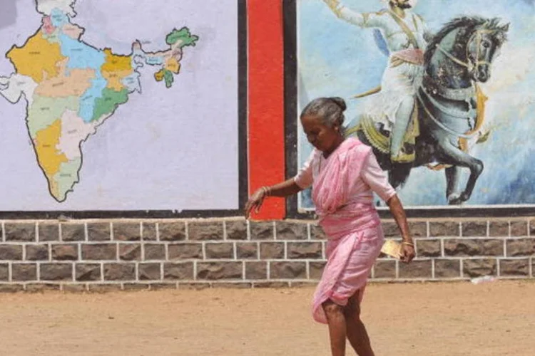 Mulher caminha em frente a mapa da Índia e a desenho do guerreiro histórico Chatrapati Shivaji (AFP/Getty Images)