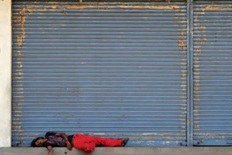 
	Trabalhador indiano dorme em frente a uma loja fechada em Bangalore durante a greve geral no pa&iacute;s: governo tenta imp&ocirc;r reformas consideradas &quot;contra os pobres&quot;
 (Manjunath Kiran/AFP)