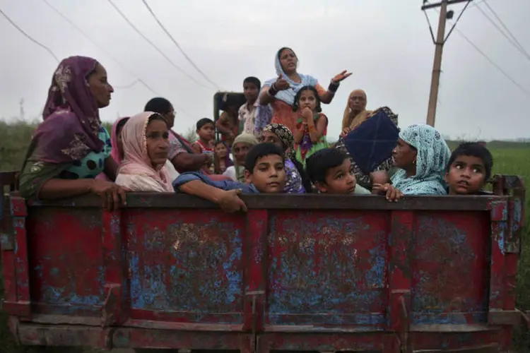 Indianos fogem para lugar seguro: episódios violentos na segunda-feira mataram 9 civis (Mukesh Gupta/Reuters)
