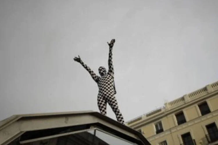 "Indignado" sobe na entrada do metrô da Praça do Sol, onde foi montado um acampamento improvisado pelos manifestantes (Pedro Armestre/AFP)