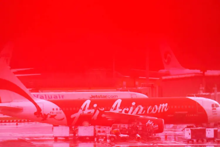 Avião da AirAsia é visto através de um sinal vermelho na parede (REUTERS/Edgar Su)