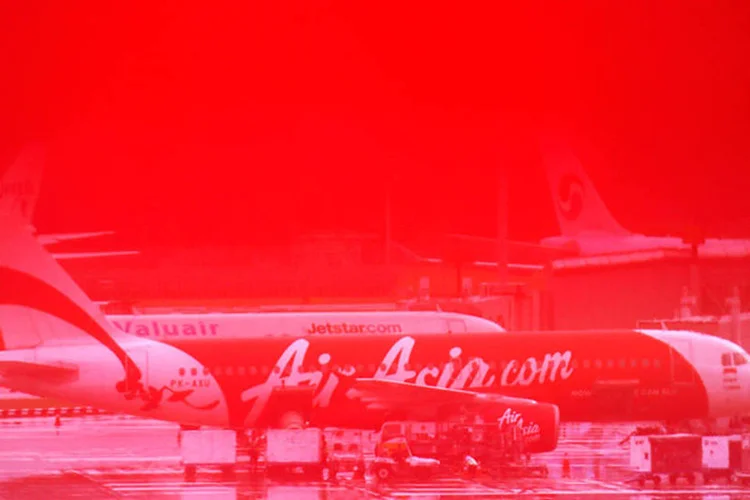 Avião da AirAsia é visto através de um sinal vermelho na parede (REUTERS/Edgar Su)