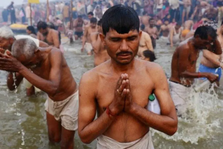 Devotos hindus rezam nas águas do Ganges durante a Kumbh Mela em Allahabad, na Índia (©afp.com / Roberto Schmidt)