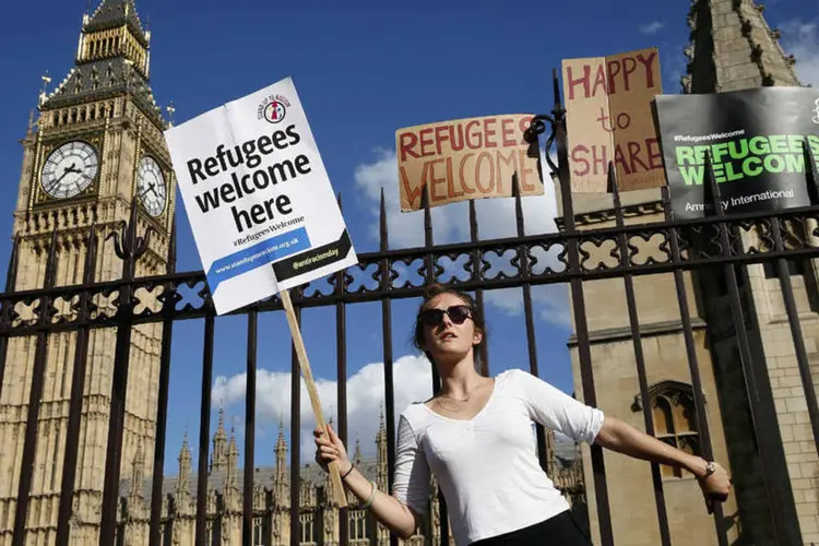 
	Manifestante em frente ao parlamento ingl&ecirc;s, a favor dos refugiados s&iacute;rios
 (REUTERS/Stefan Wermuth)