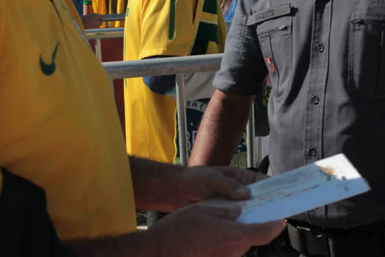 Torcedor mostra ingresso à policial para passar poder seguir em direção ao estádio (Beatriz Souza/ EXAME.com)