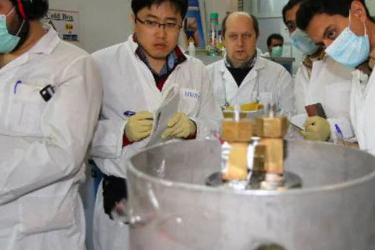 
	Inspetores da AIEA e t&eacute;cnicos iranianos, na central nuclear de Natanz: relat&oacute;rio deixou claro que at&eacute; agora o pa&iacute;s est&aacute; tomando atitudes acordadas para reduzir seu programa nuclear
 (Kazem Ghane/AFP)