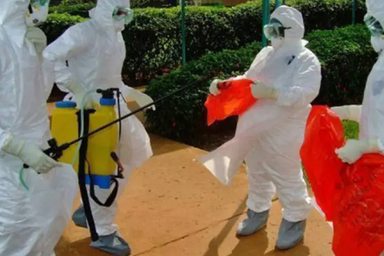 Integrantes da OMS: equipe se prepara para entrar no hospital Kagadi de Uganda em meio a uma epidemia de Ebola (Isaac Kasamani/AFP)