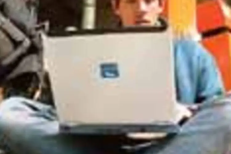 Jovem usa seu laptop numa estação de trens na França: o avanço da internet sem fio  (--- [])